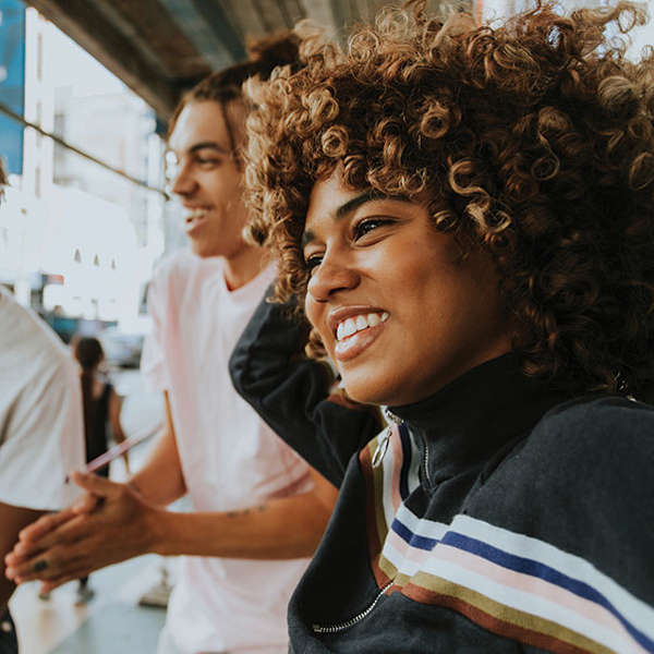 African American teen woman laughs with her peers