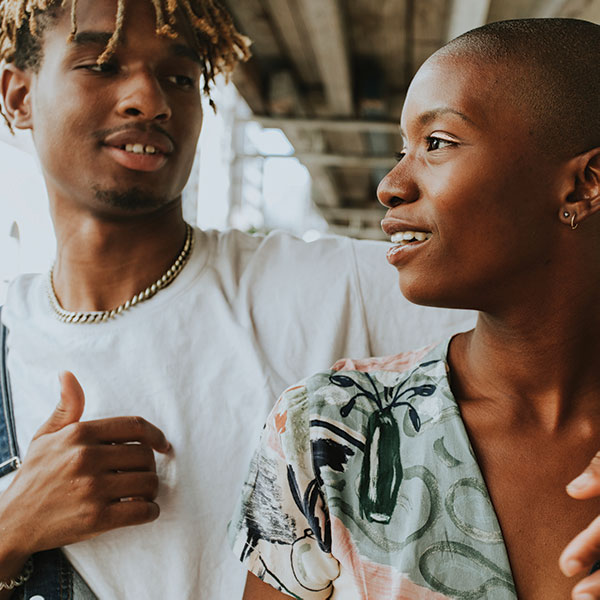 two African American teens talk in the hallway at school