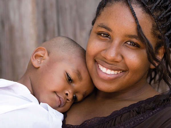 adoptive mother hugs her son close