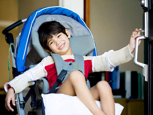 a young asian boy with special needs sits in his wheelchair