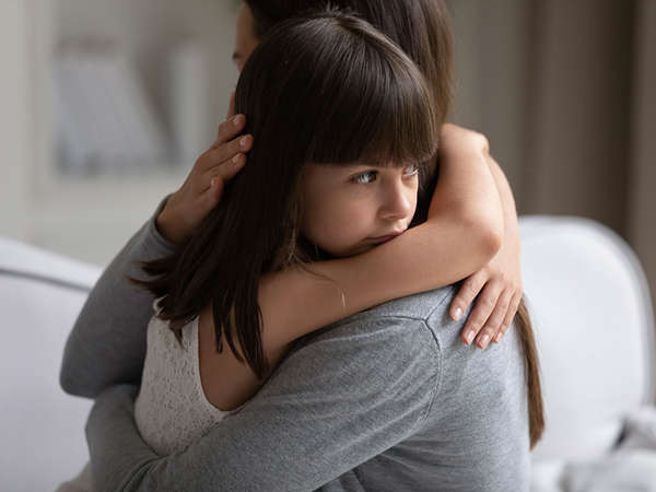 an african american teenage boy hugs his toddler sister in their foster parents' home