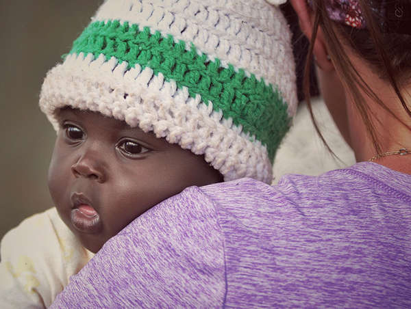 Refugee child in the arms of his foster parent