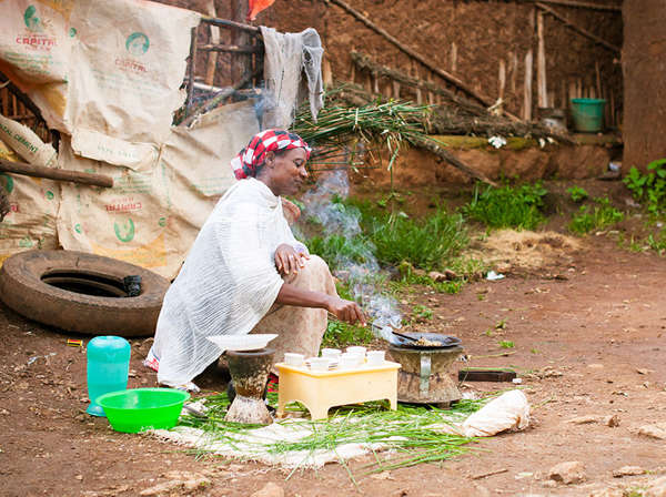Ethiopian woman cooks rice outside her home