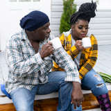 A teen girl and her dad drink coffee on the front porch