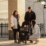 Young white adoptive couple meets with birth mother and baby on urban street