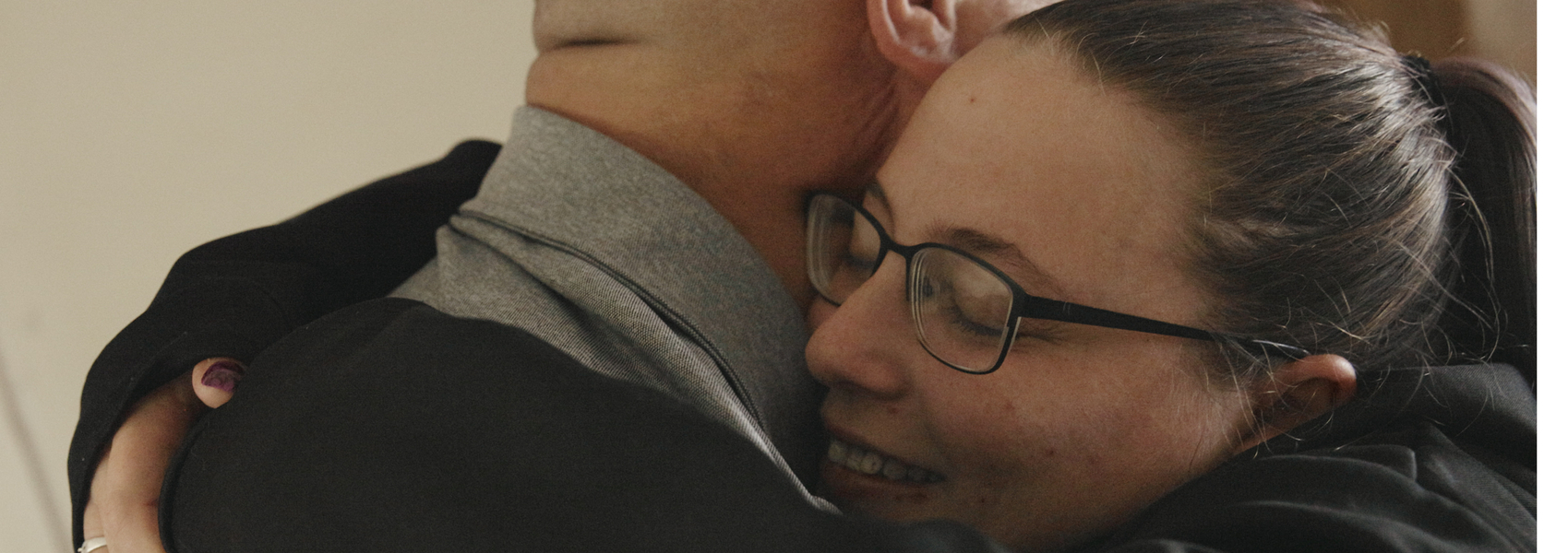 Adult woman hugs her uncle who provided kinship care