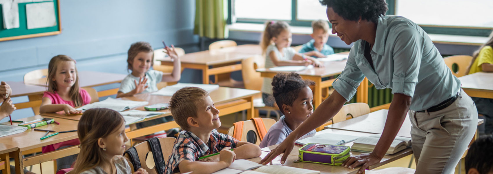 A teacher talks with an elementary school student.