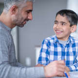 Afghan refugee boy listens to adult male mentor