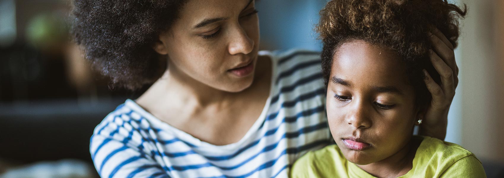 A mother comforts a young girl who is calm after a meltdown. 