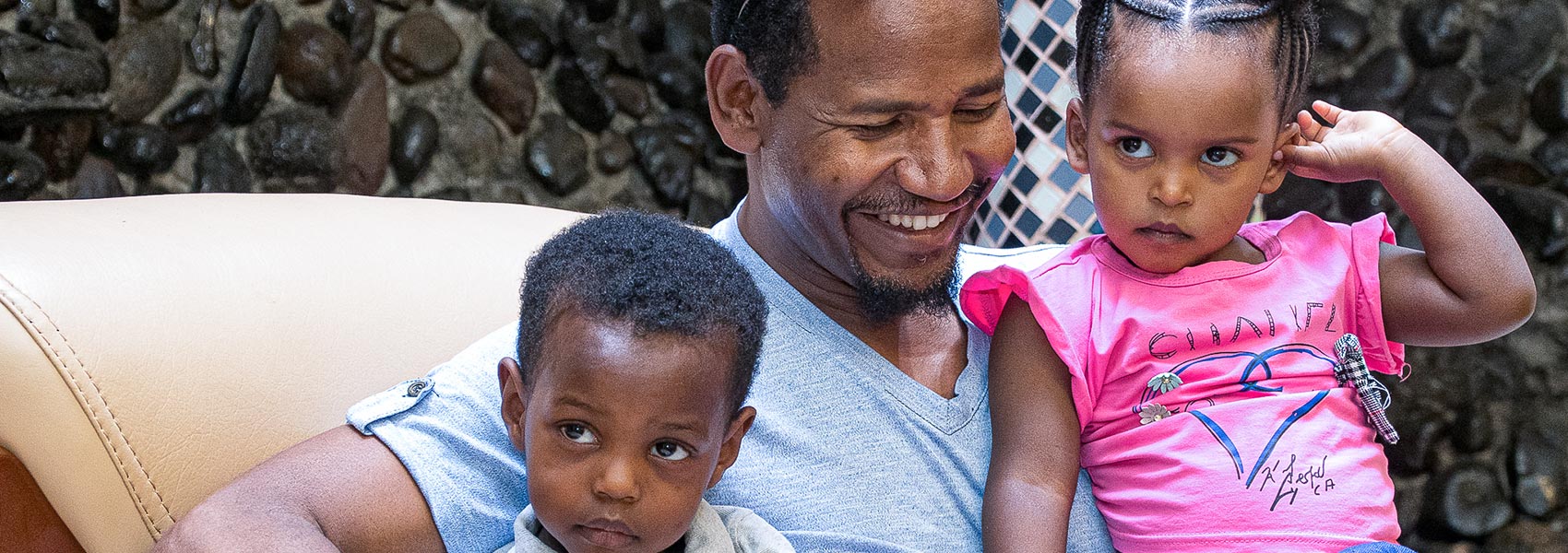 ethiopian father sitting with two children on his lap