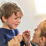 A mother comforts a young boy who is in a meltdown. 