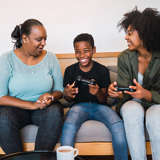 Adoptive mom with son and birth mom playing games together.