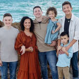 diverse family with teenagers adopted from foster care pose at beach