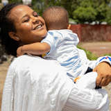 Ethiopian mother hugs young toddler in her arms.