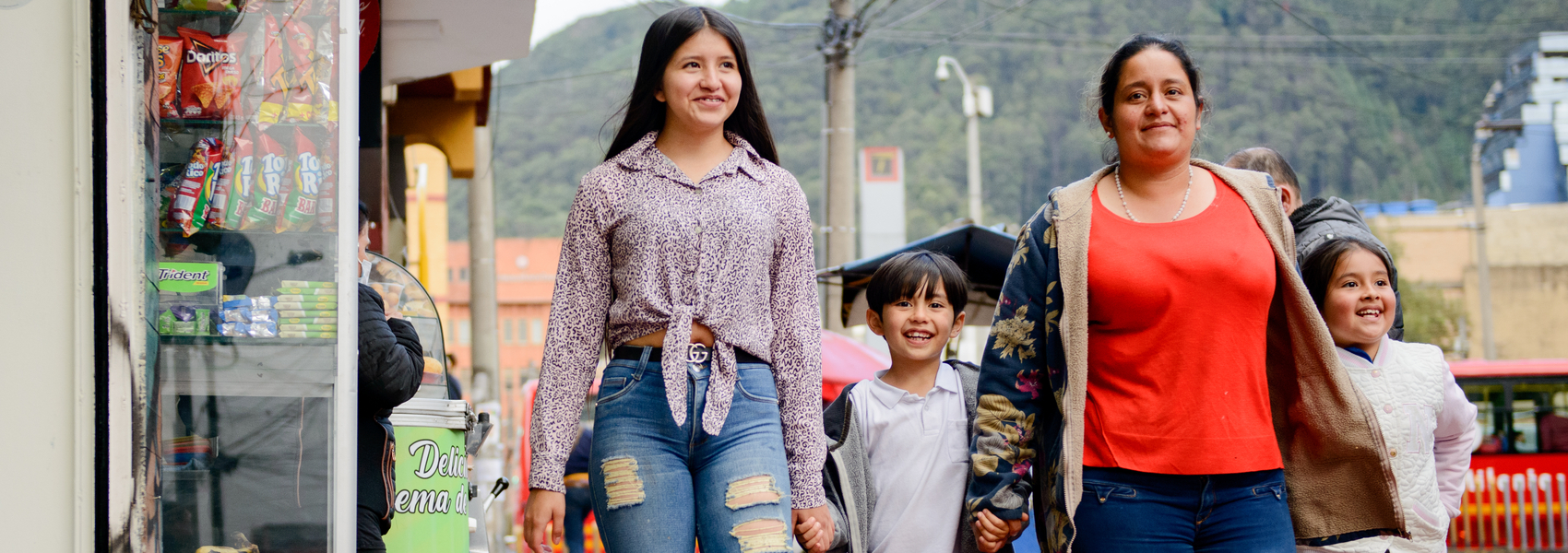 Colombian refugee woman Jeidi walks city streets with her children