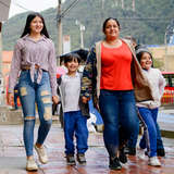 Colombian refugee woman Jeidi walks city streets with her children