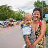 venezuelan mother holds her toddler son as they cross into safety in Colombia