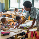 A teacher talks with an elementary school student.