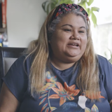 Diverse refugee foster parents sit in living room