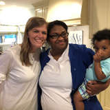 african american mother holds her son while standing with their host parent