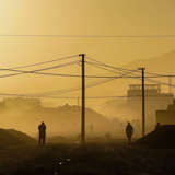 Dark figures walk through a city in Afghanistan 