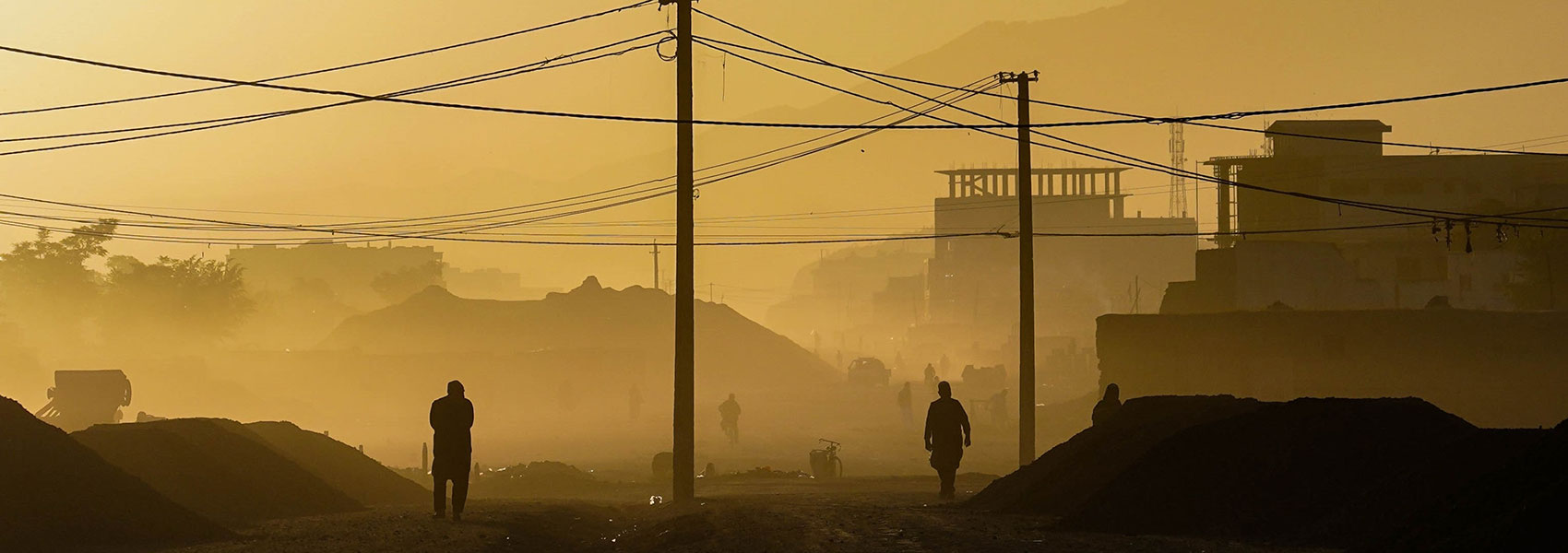 Dark figures walk through a city in Afghanistan 