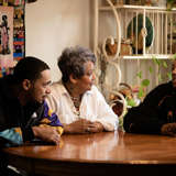 foster mother and young man smile at the dinner table