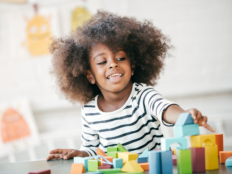 young african american girl plays with blocks