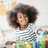 young african american girl plays with blocks