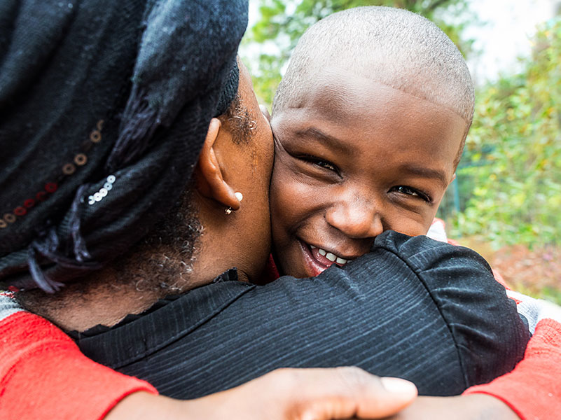 foster mother in haiti hugs young boy