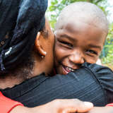 foster mother in haiti hugs young boy