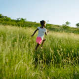 young haitian girl runs through a meadow as she tries to find her way home