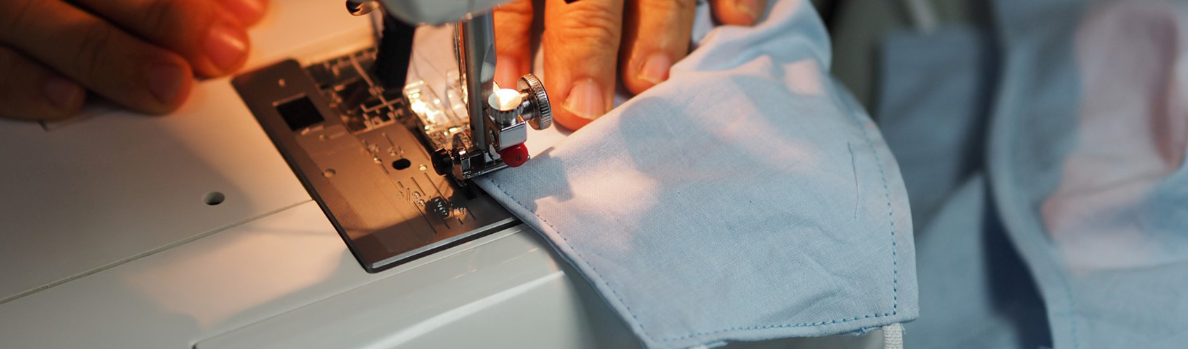 Threading the needle: A refugee uses his tailoring skills to serve his community Banner Image